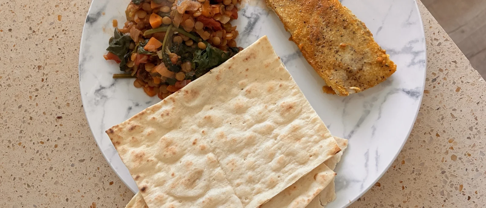 Homemade lentil Dahl served with fish on a plate, presented as a fresh and healthy meal