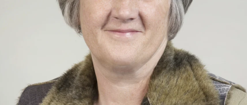 Portrait of a girl with short grey hair and a furry collar smiling 