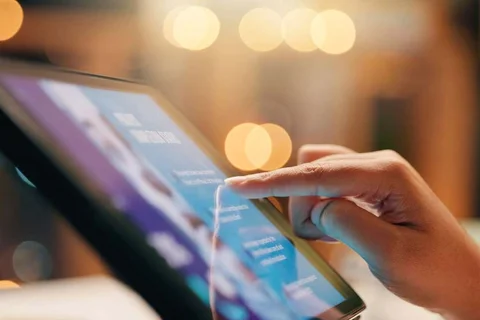 Close-up of a hand interacting with a digital tablet
