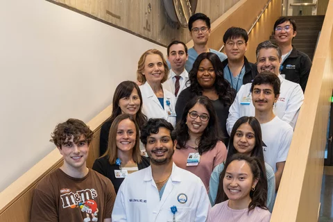 Students with medical professionals posing for picture on stairwell