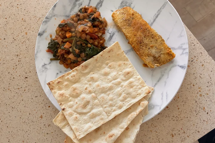 Homemade lentil Dahl served with fish on a plate, presented as a fresh and healthy meal