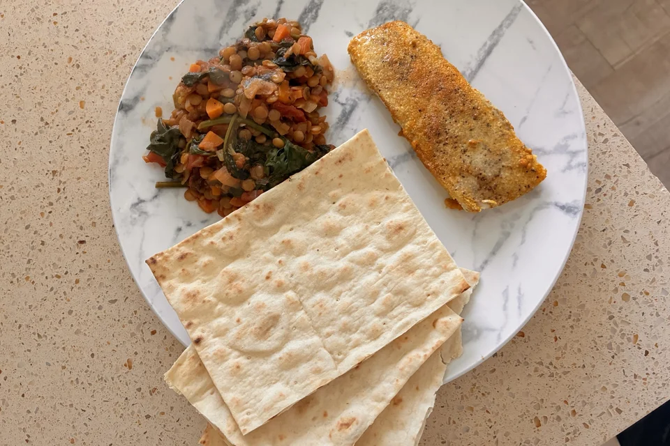 Homemade lentil Dahl served with fish on a plate, presented as a fresh and healthy meal
