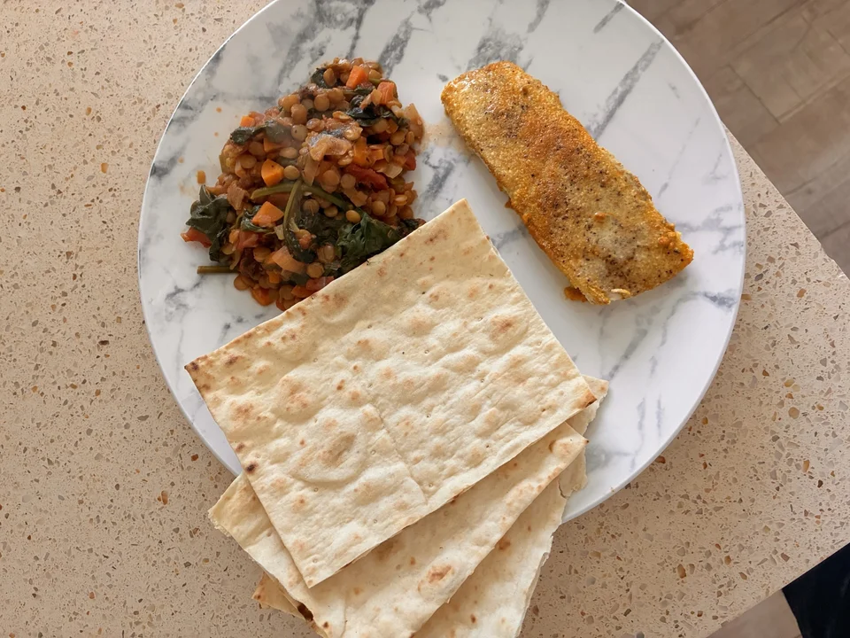 Homemade lentil Dahl served with fish on a plate, presented as a fresh and healthy meal