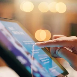 Close-up of a hand interacting with a digital tablet