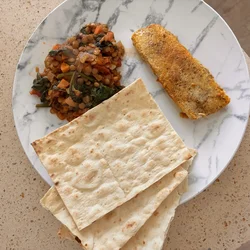 Homemade lentil Dahl served with fish on a plate, presented as a fresh and healthy meal