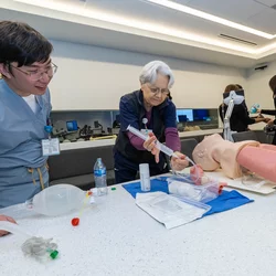 Instructor and student practicing operation on model