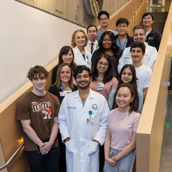 Students with medical professionals posing for picture on stairwell