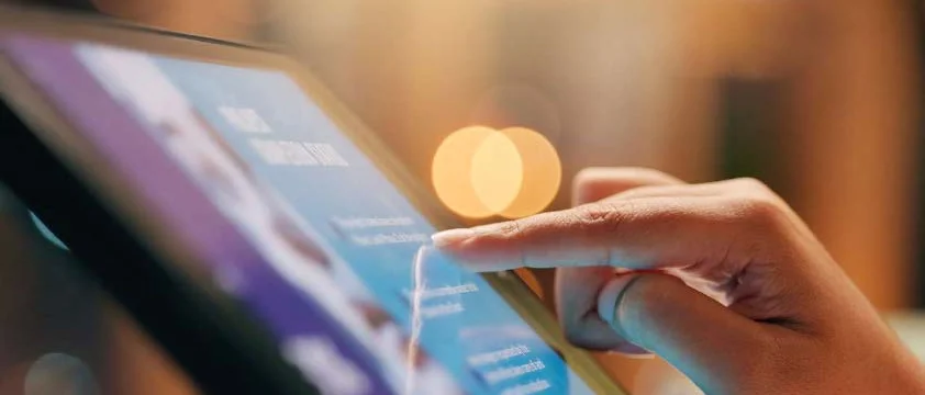 Close-up of a hand interacting with a digital tablet