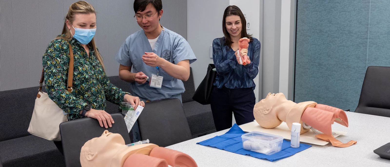 Three UCLA members viewing simulation models