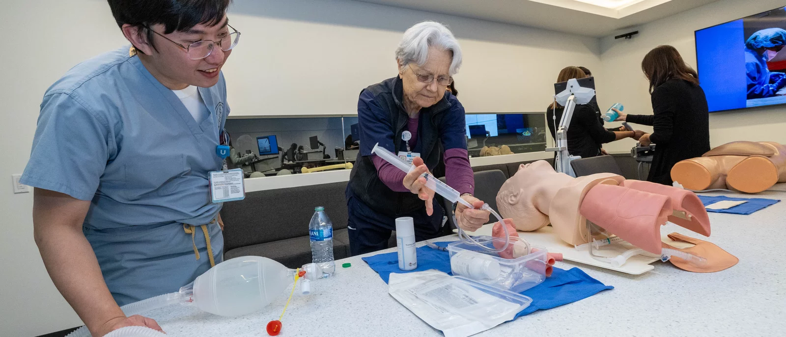 Instructor and student practicing operation on model