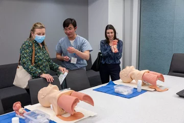 Three UCLA members viewing simulation models