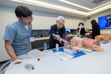 Instructor and student practicing operation on model