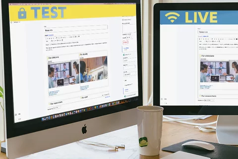Two monitors on a desk: the left shows a site in edit mode with a 'live' banner, the right shows the same site with a 'test' banner.