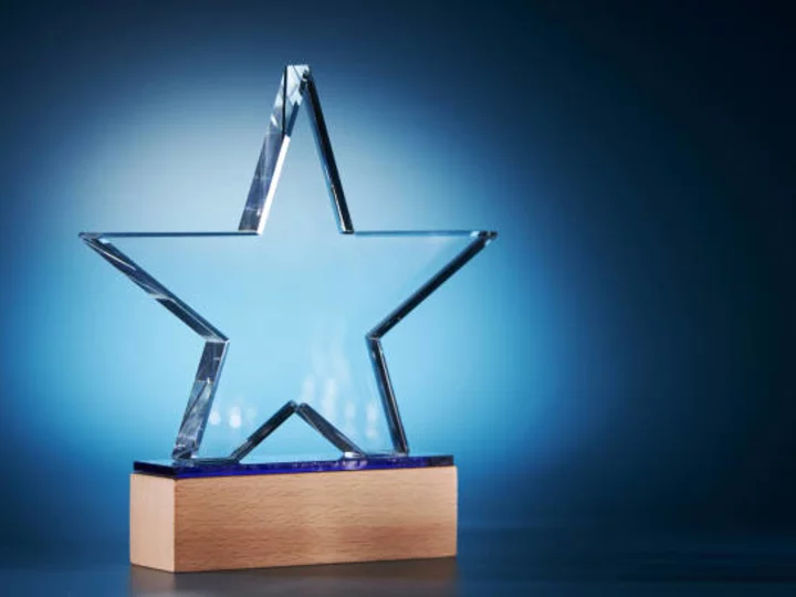 Clear star shaped crystal on wooden base against blue background