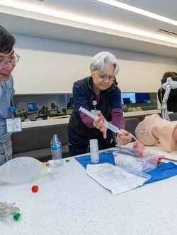 Instructor and student practicing operation on model