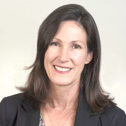 A woman smiling at the camera. The photo is in the style of a headshot for a resume
